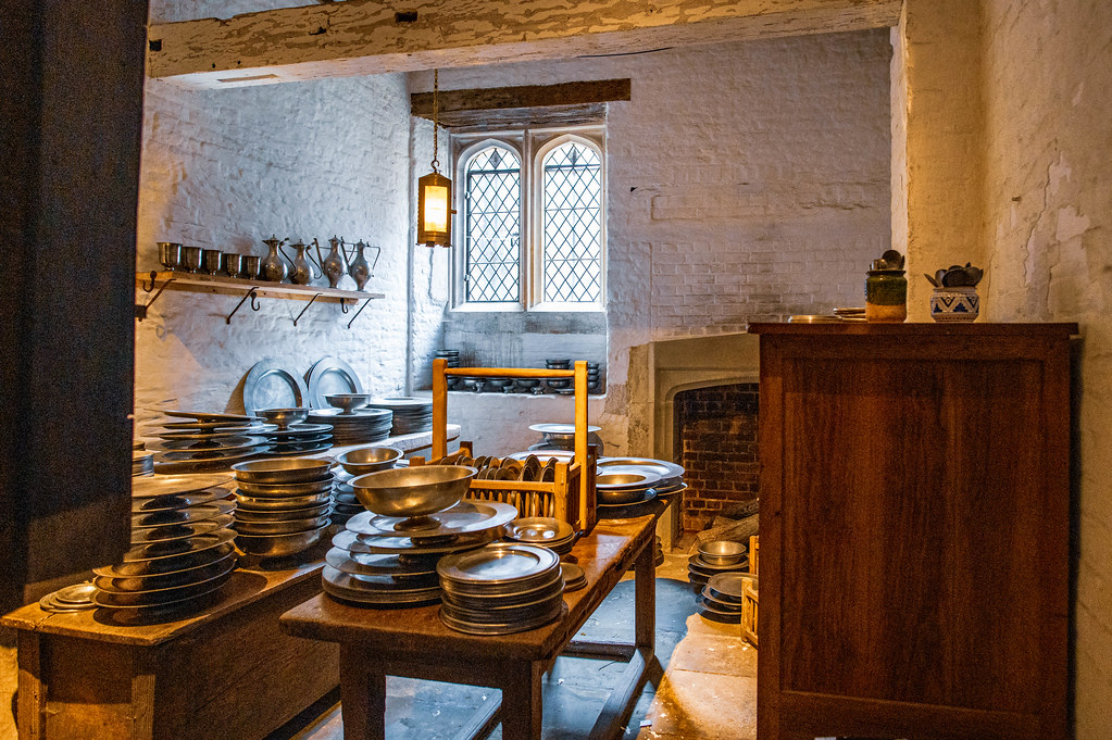 The Tudor kitchens at Hampton Court Palace, with pewter dishes on a long wooden table