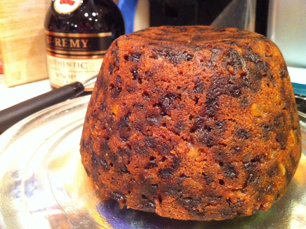A dark, fruity Christmas pudding on a plate